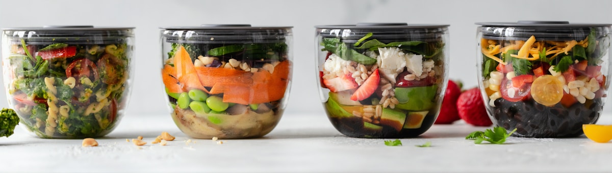 Cuatro botes con ensaladas y verdura preparados para la semana